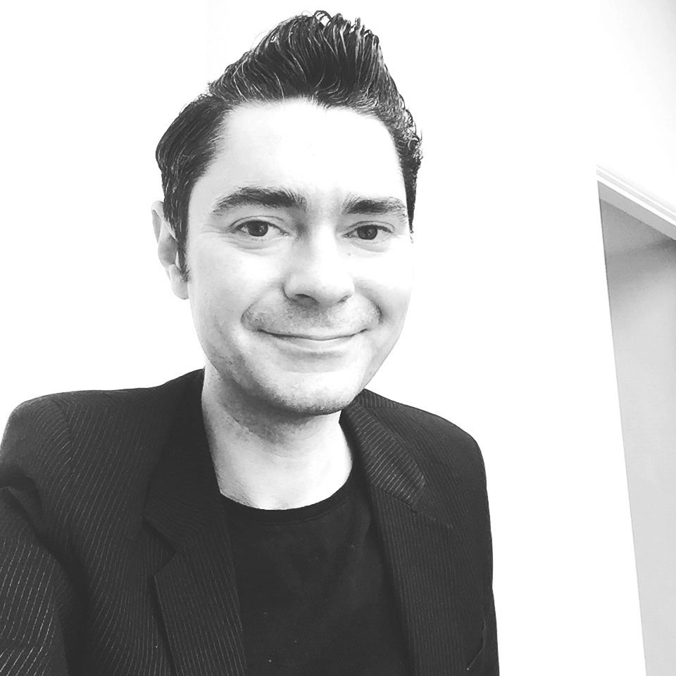 Black and white image of author Nik Perring smiling at us