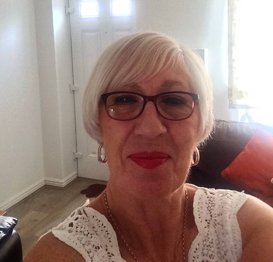 Author Liz McKittrick poses for a photograph, smiling in a well lit room
