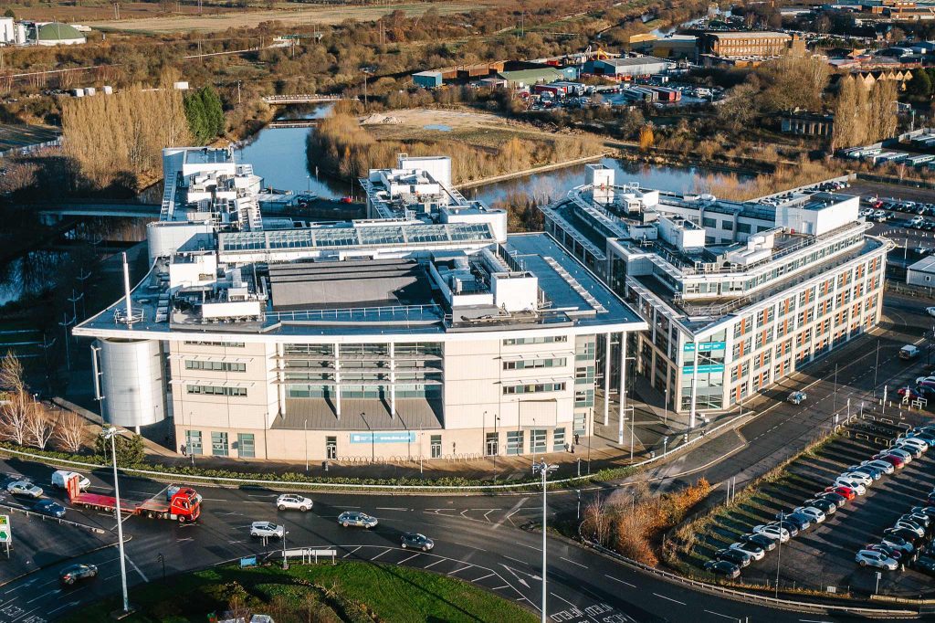 Image of a large glass building with the sign 'Doncaster College' displayed on the side.